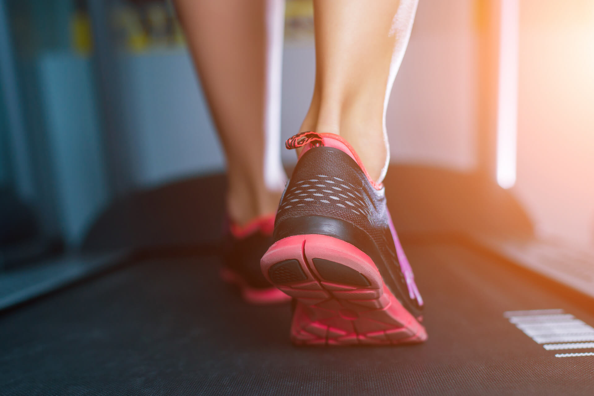 woman's feet walking on treadmill at gym